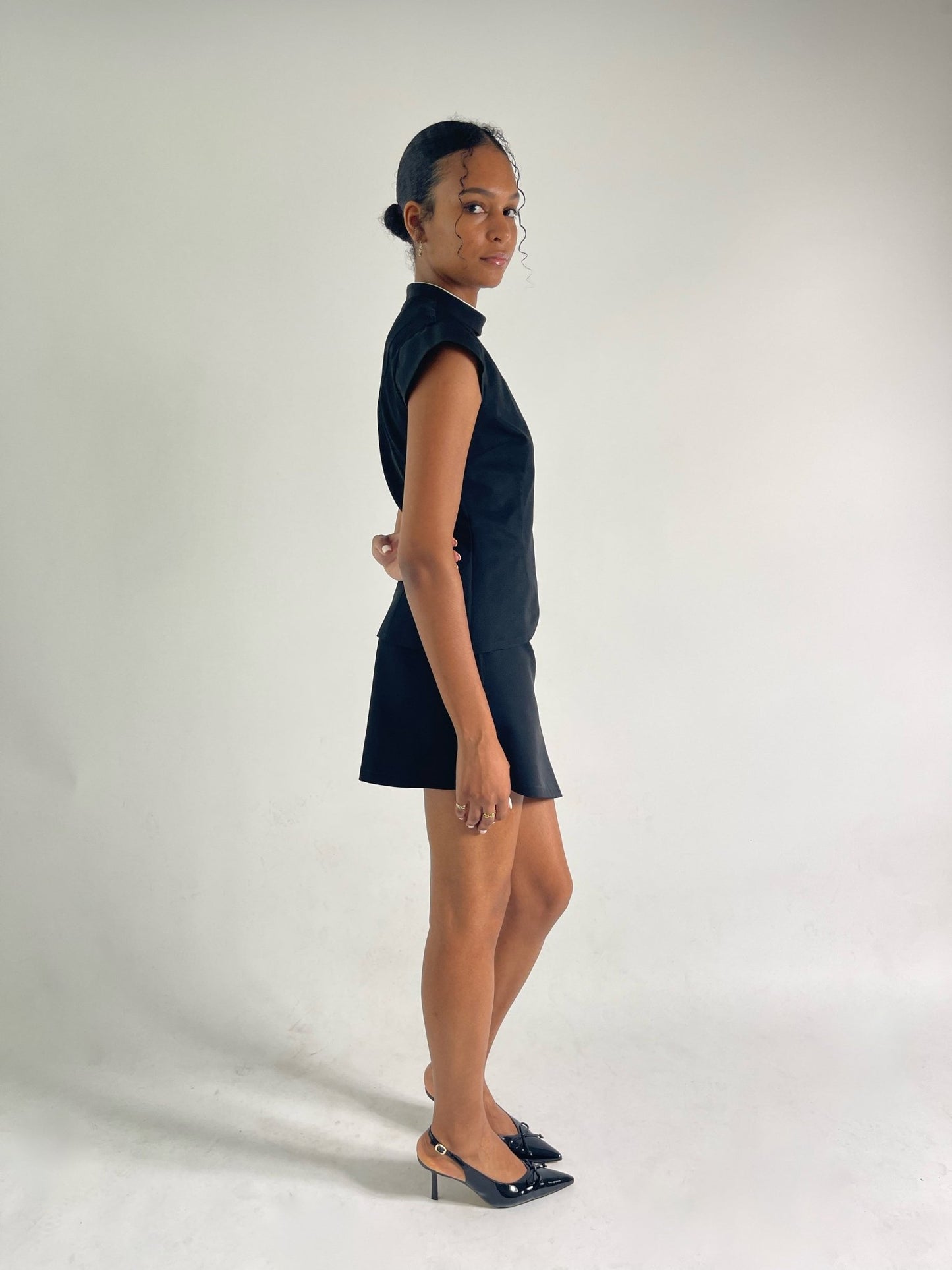 black vest with collar and capped sleeves with black mini skirt
