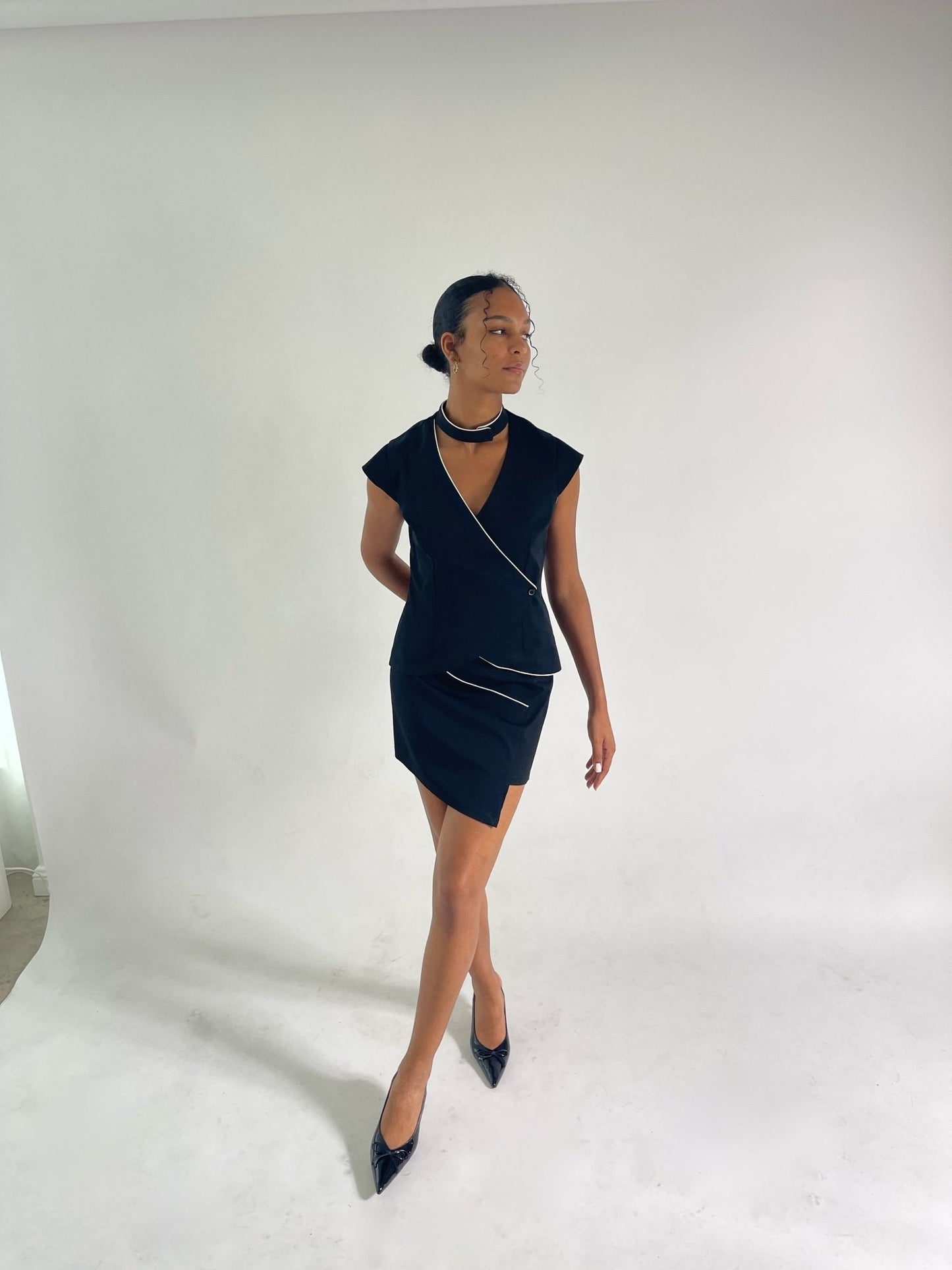 matching black vest and skirt set with capped sleeves and ivory piping