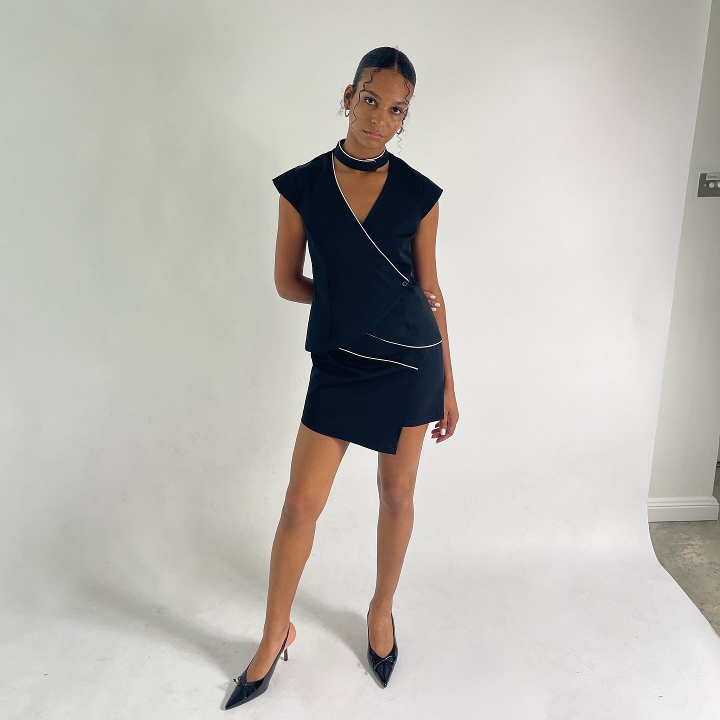 black vest with capped sleeves and button closure