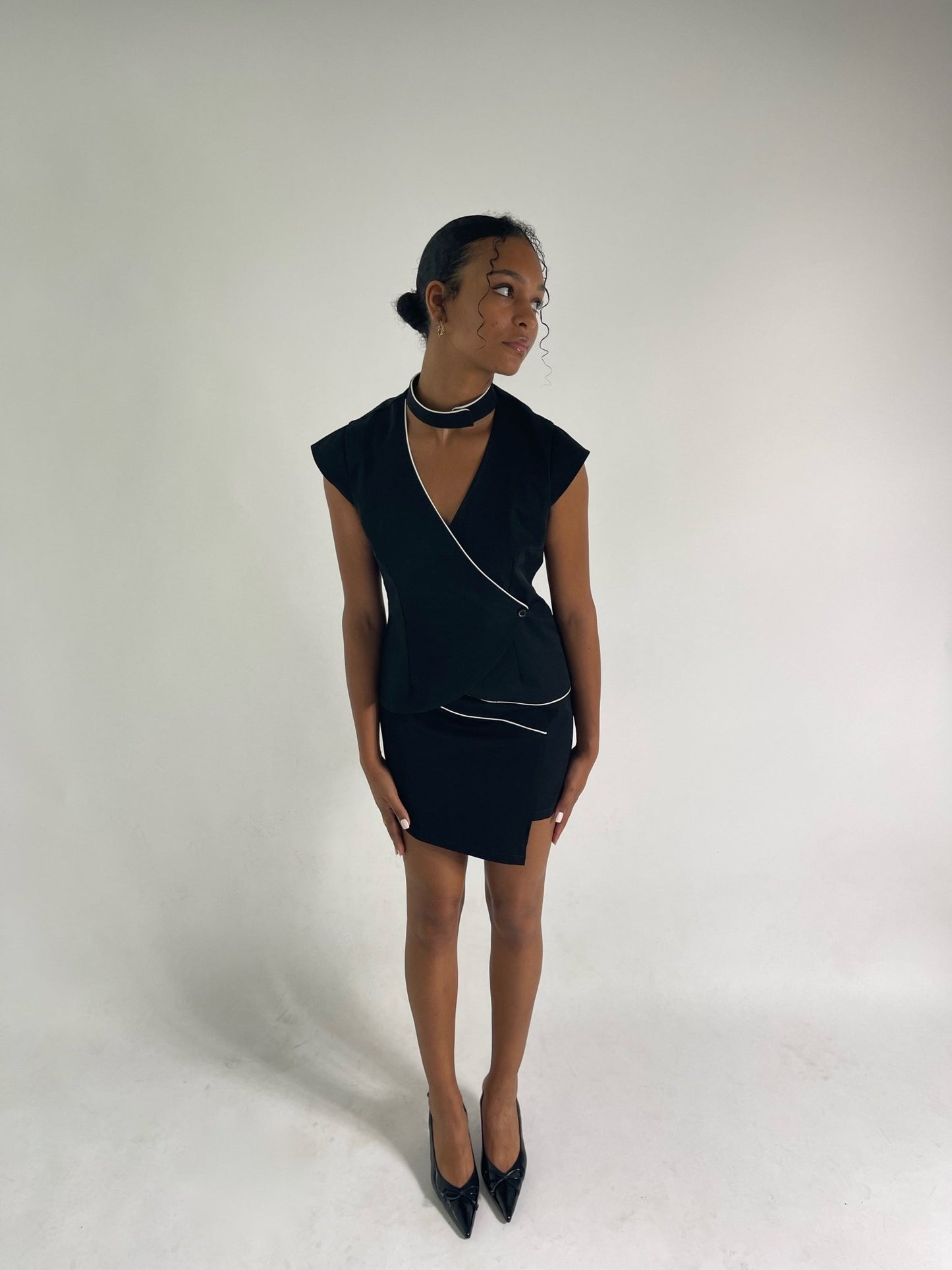 black tailored vest with v neckline and ivory sating piping