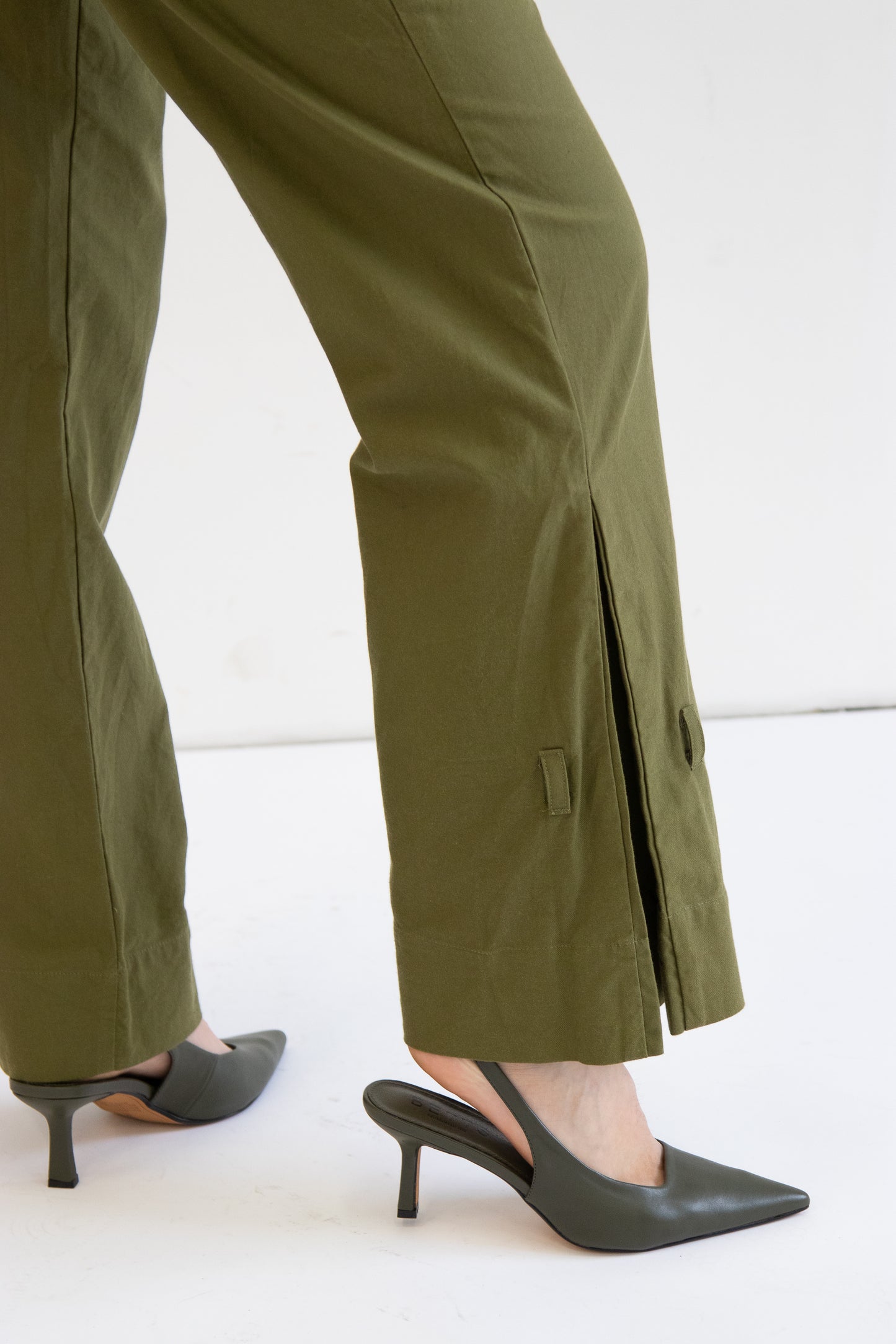 Close up side view of cotton khaki pants showing box pleat hem detail