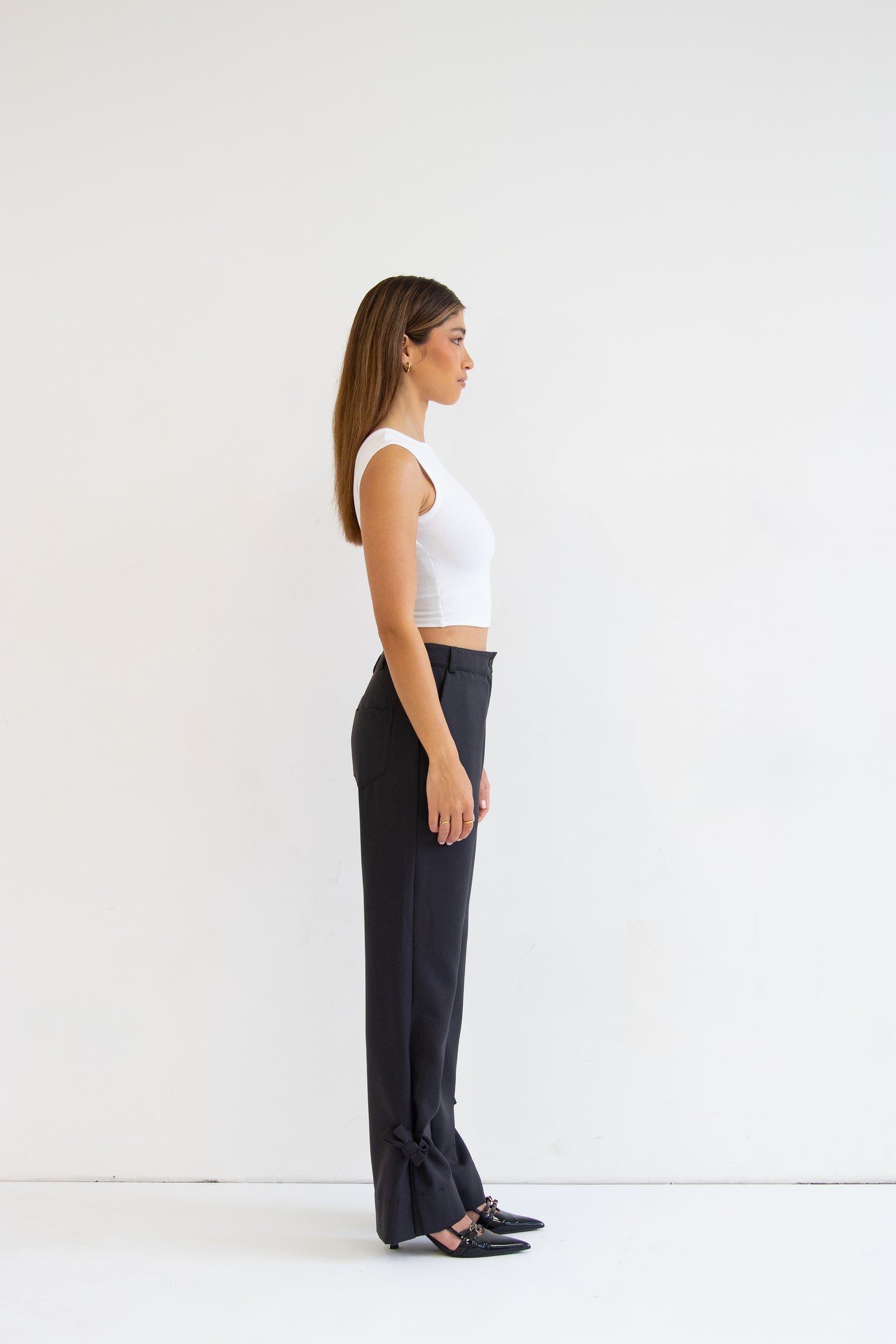 Side view of model wearing grey wool blend pants with ties at hem