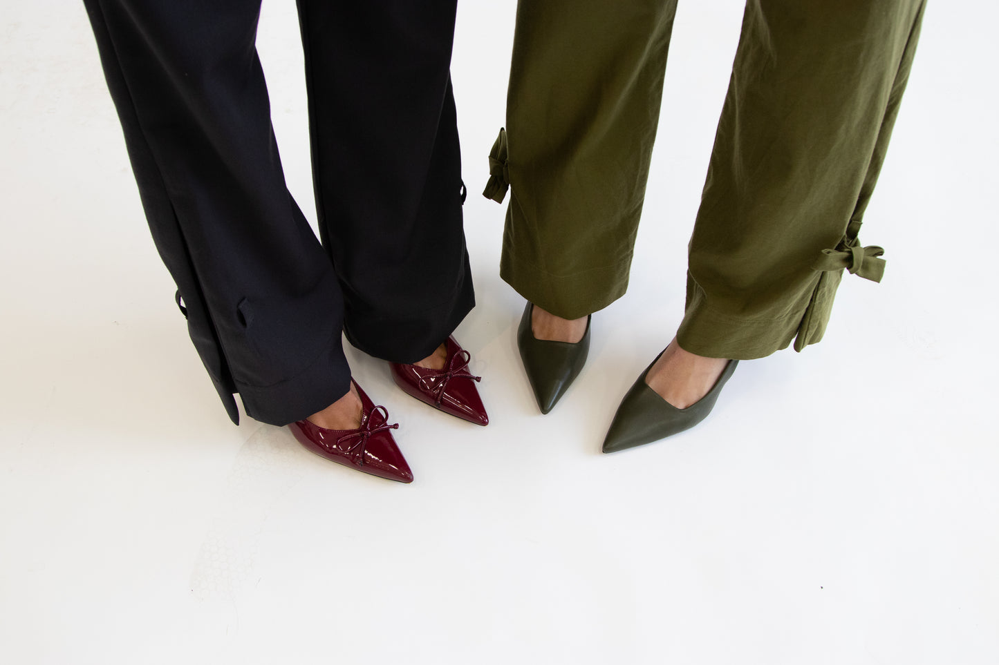 Close up of two models feet showing grey and khaki pants with and without ties at hem