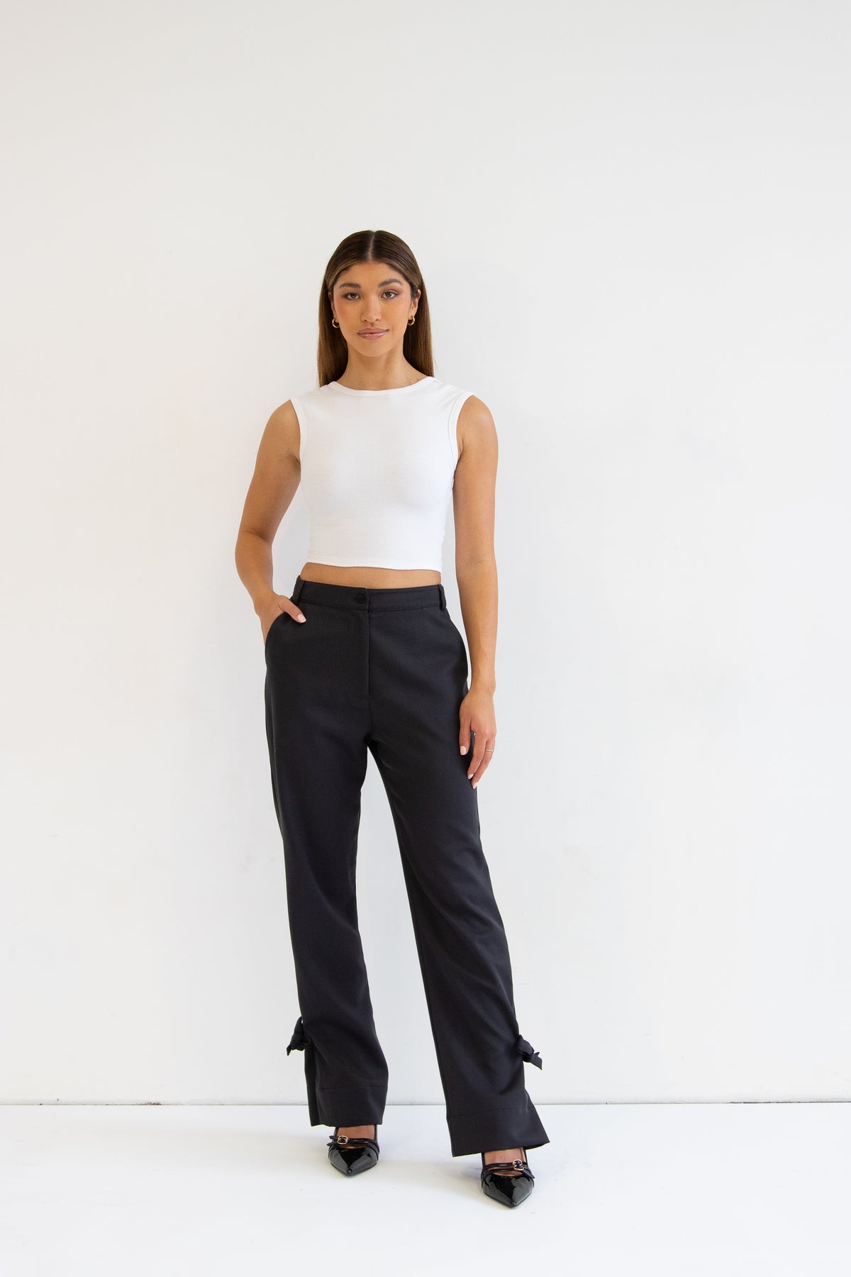 Model wearing grey wool blend pants with white top