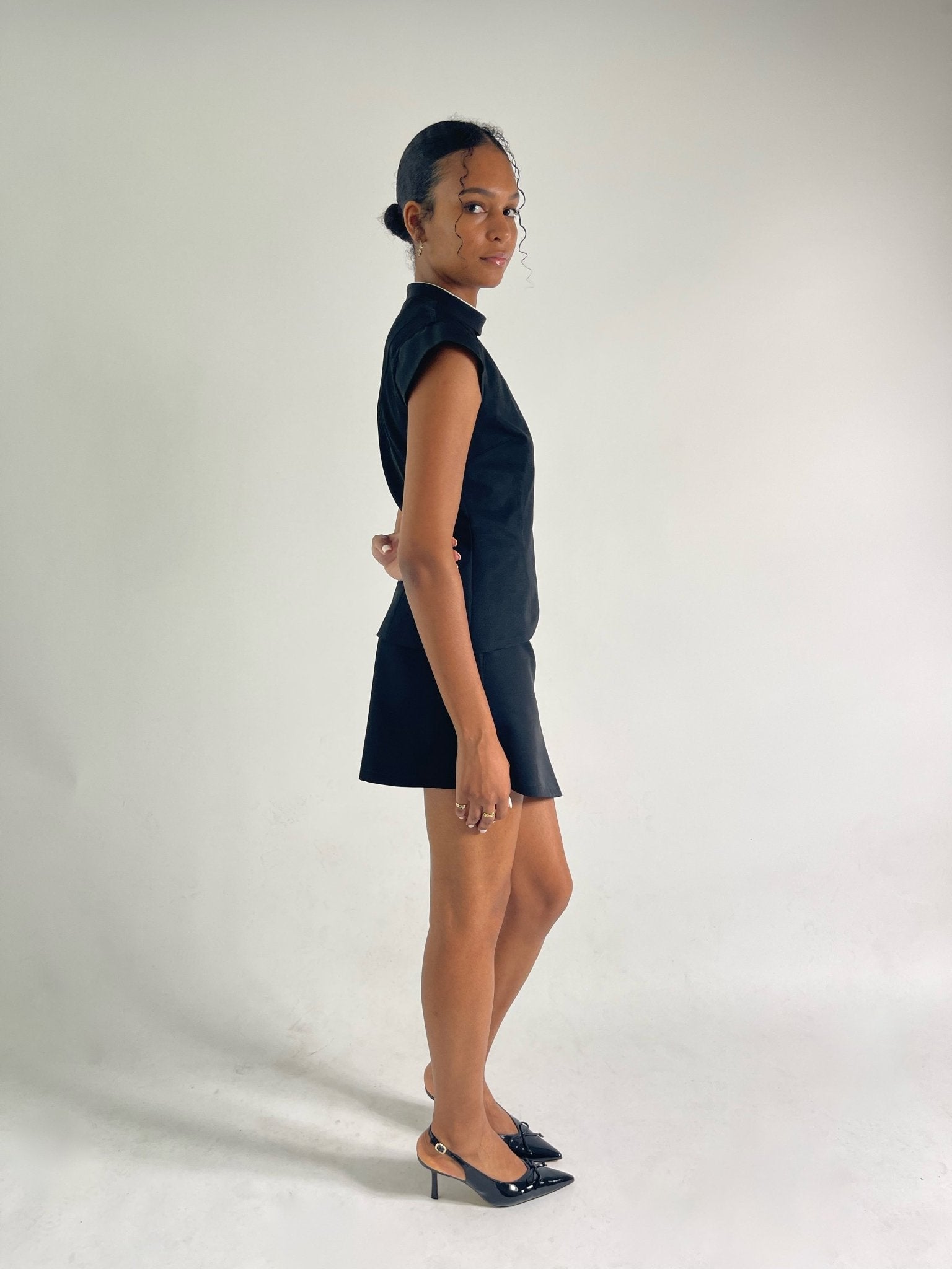 black vest with collar and capped sleeves with black mini skirt